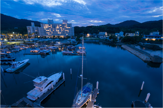Awaji Island harbor at dusk with fishing boats on calm water, reflecting the quiet coastal rhythm of island life
