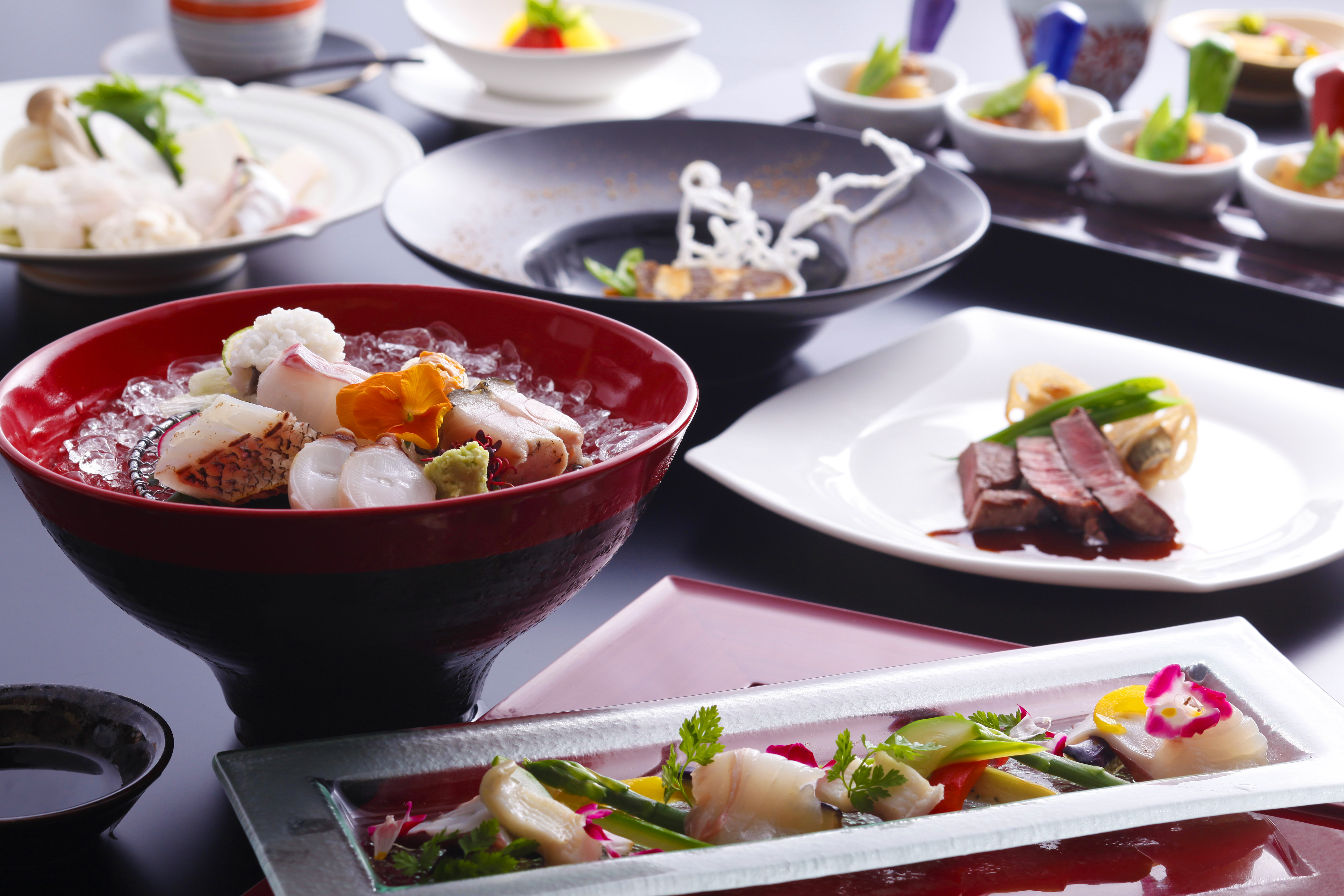 Elegant multi-course Japanese dining spread with lacquered and ceramic vessels, reflecting the seasonal craft at the heart of Hotel New Awaji Group's culinary experience