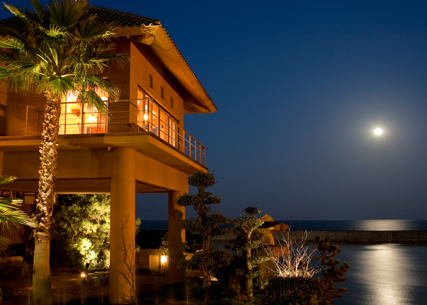 Awaji Yumesenkei illuminated exterior with ocean views at dusk, creating a calm and elevated resort atmosphere