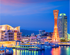 Kobe harbor skyline at night with illuminated tower, showcasing a vibrant and modern waterfront city