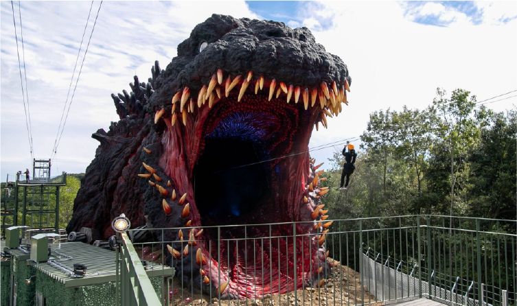 Guests ziplining into a massive Godzilla attraction at Nijigen no Mori on Awaji Island, offering a high-energy themed experience near resort stays