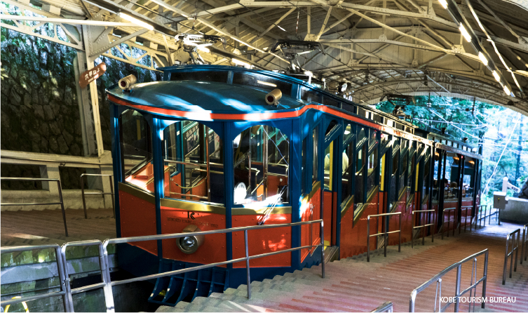 Red cable car ascending Mount Rokko, providing a unique and elevated journey with sweeping views over Kobe and Osaka Bay
