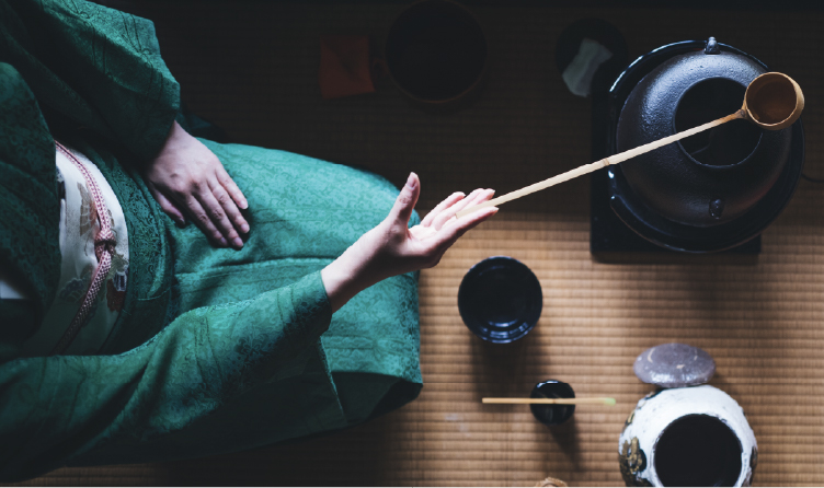 Traditional tea ceremony setting in Kyoto with hands preparing matcha, offering an intimate cultural ritual rooted in Japanese hospitality