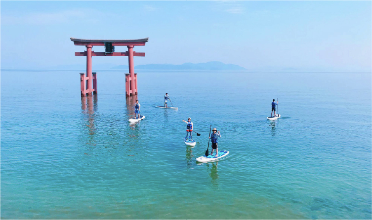 Stand-up paddleboarding near the floating torii gate at Shirahige Shrine on Lake Biwa, offering a unique and scenic water experience