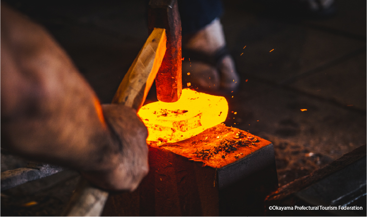 Blacksmith forging a Japanese sword with glowing steel, showcasing traditional craftsmanship and samurai-era heritage