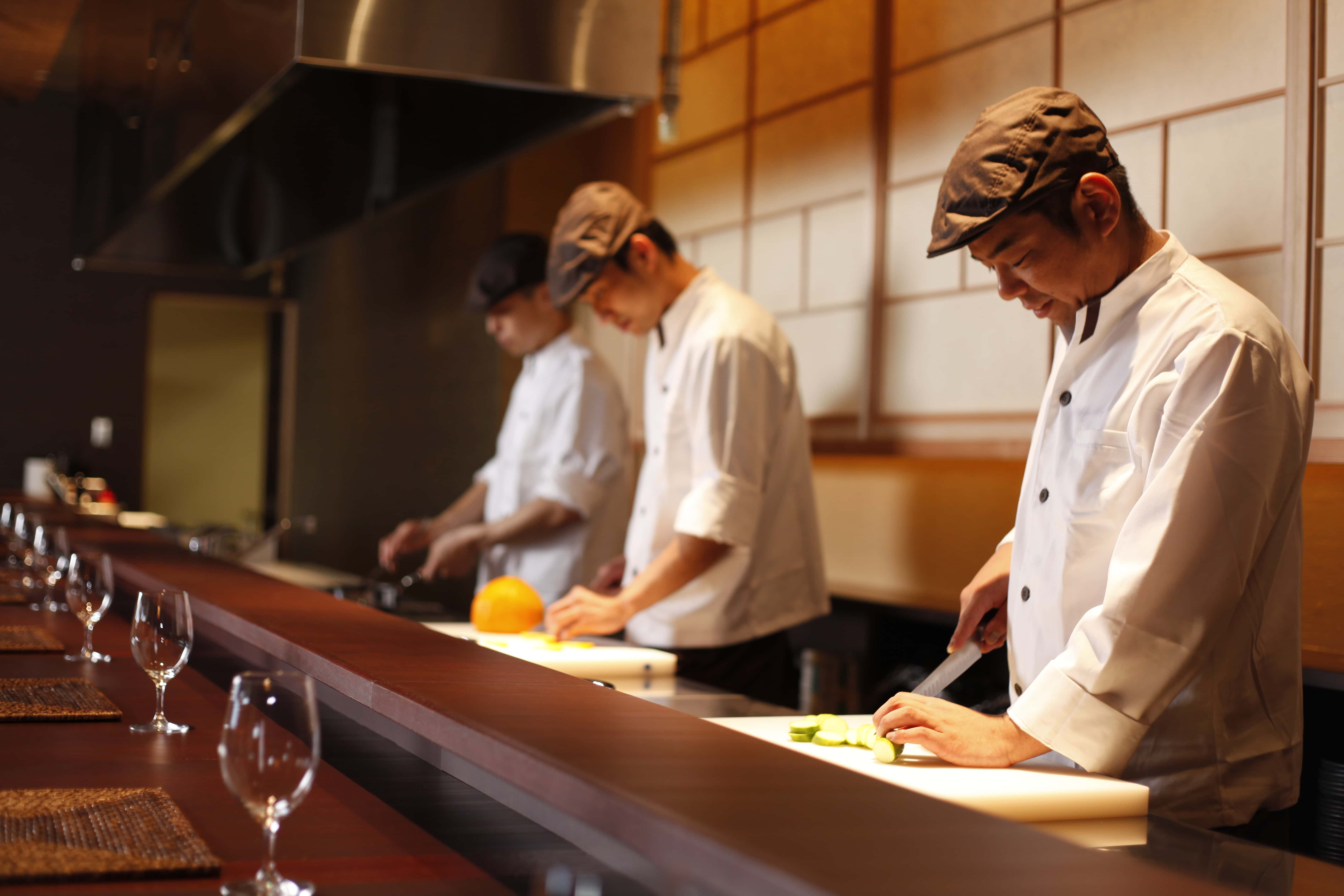 Japanese chefs preparing seasonal dishes at a kaiseki counter, immersive dining experience on Awaji Island