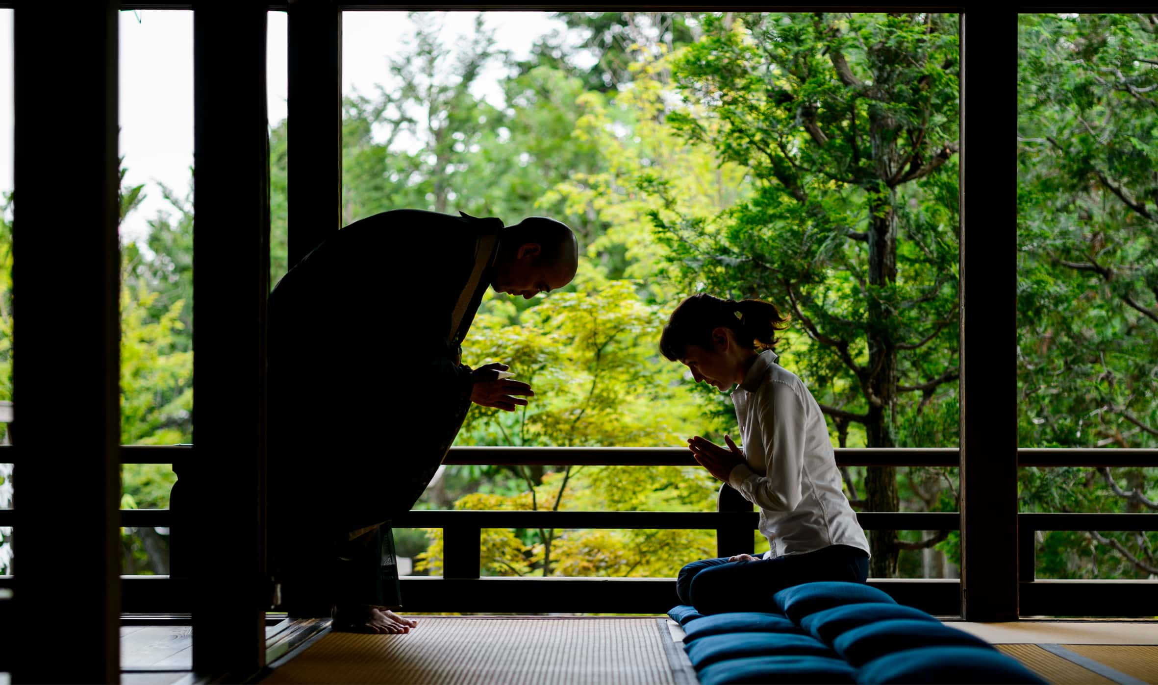 Guest experiencing traditional Japanese hospitality and bowing greeting inside a ryokan setting