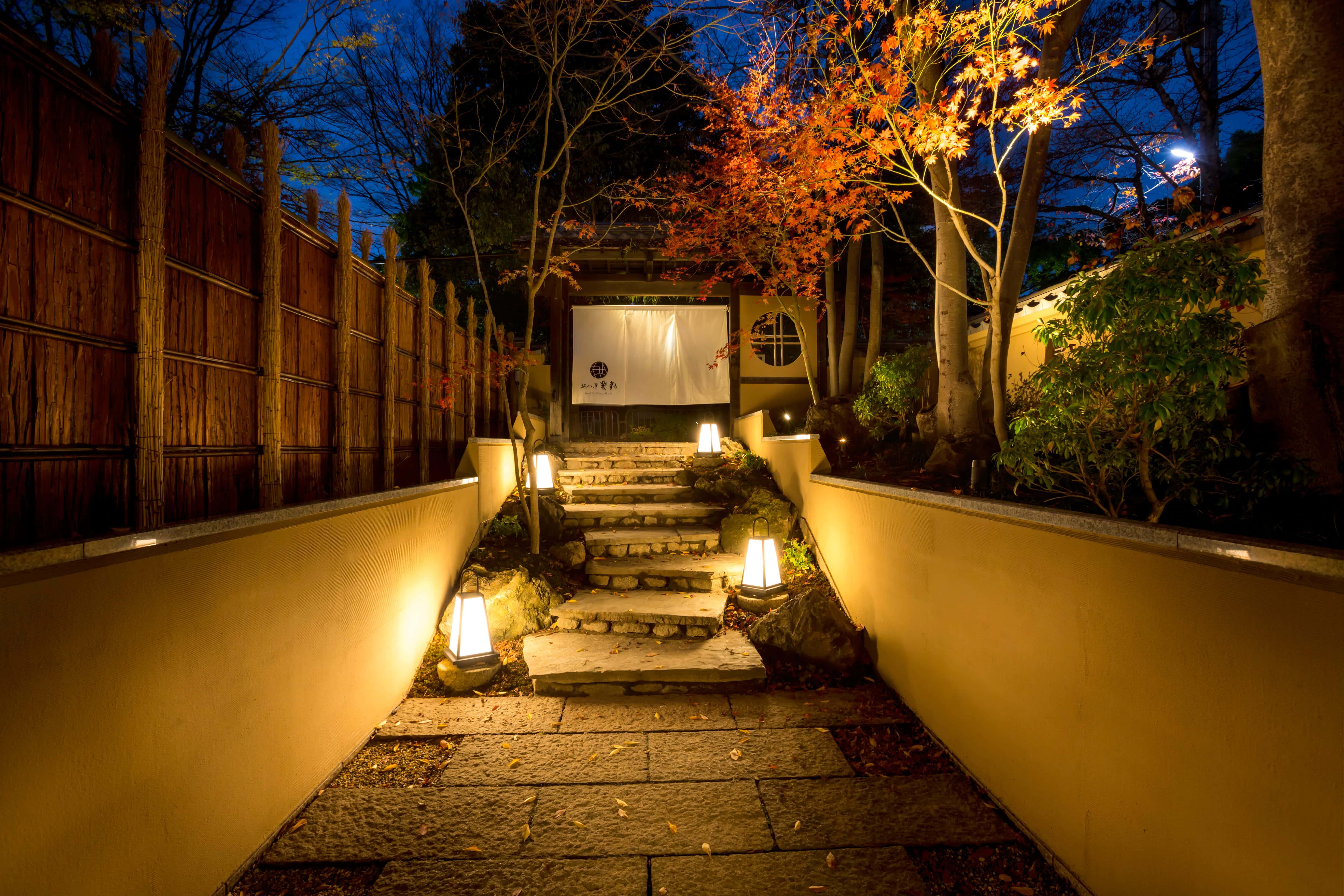 Traditional Kyoto ryokan garden pathway with stone steps and lantern lighting at dusk, Kyoto Japan