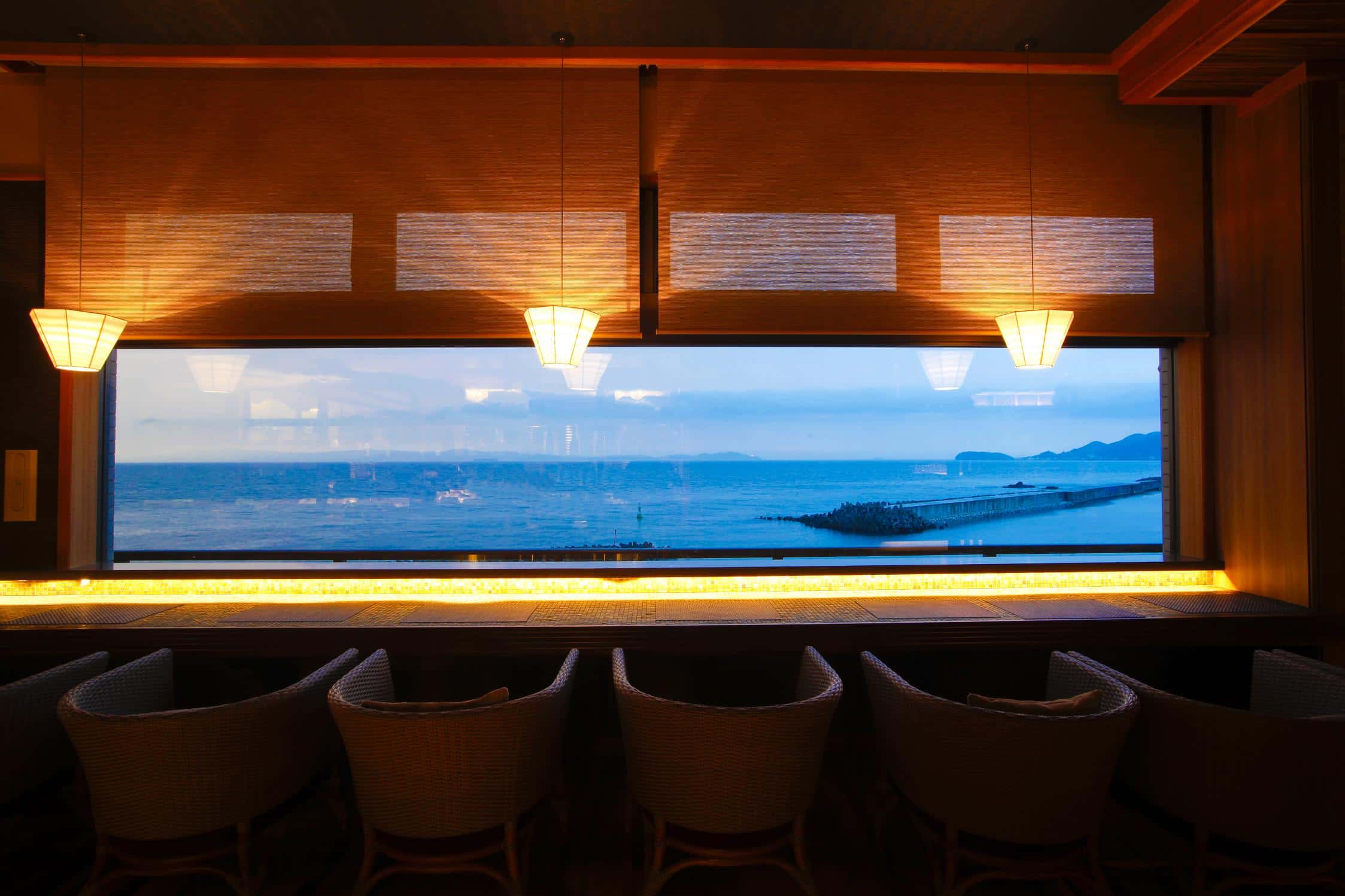 Grand hotel lobby with staircase and warm lighting at Hotel New Awaji Group, luxury hospitality in Japan