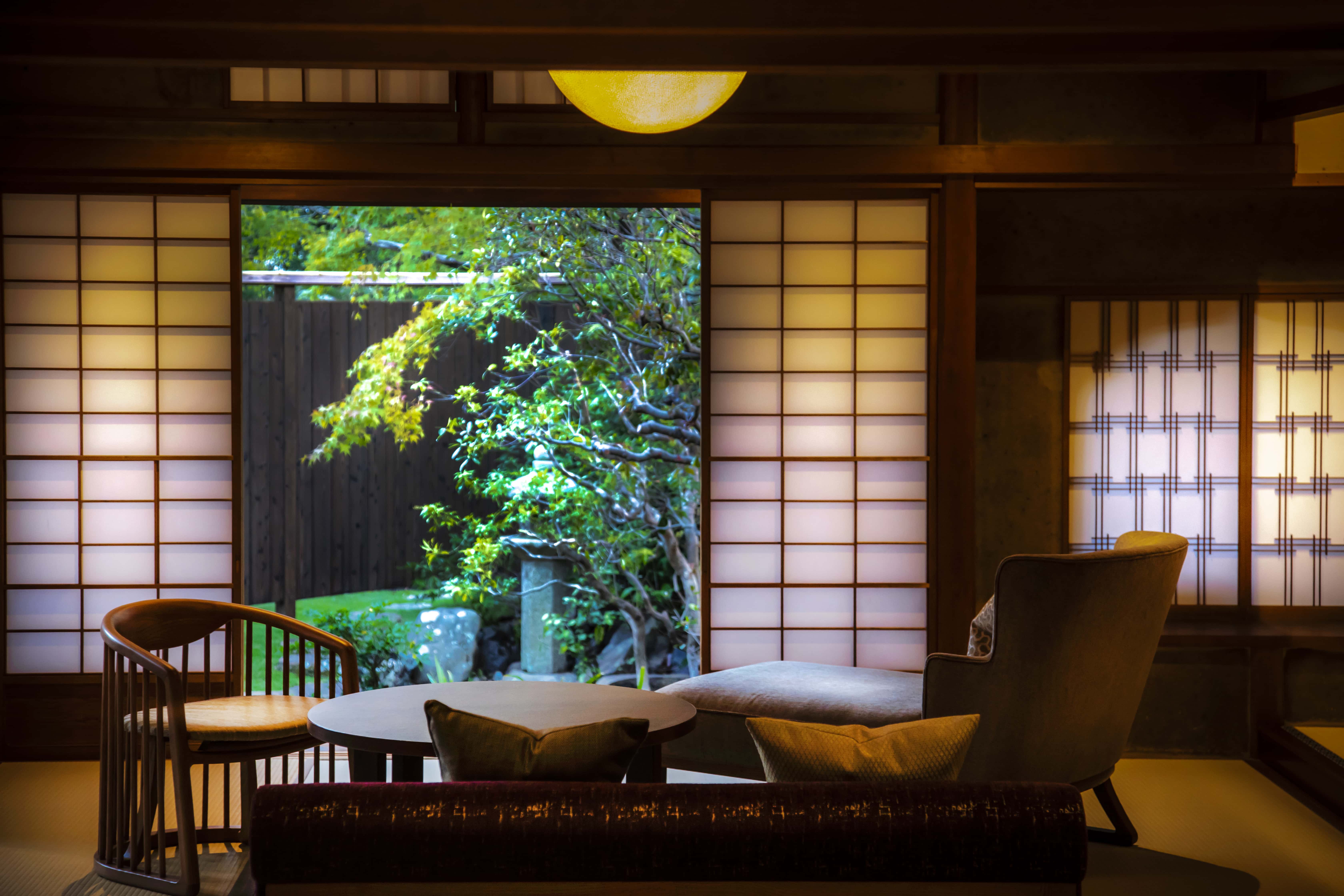 Traditional Japanese guest room with shoji screens and garden view, ryokan-style interior in Kyoto Japan