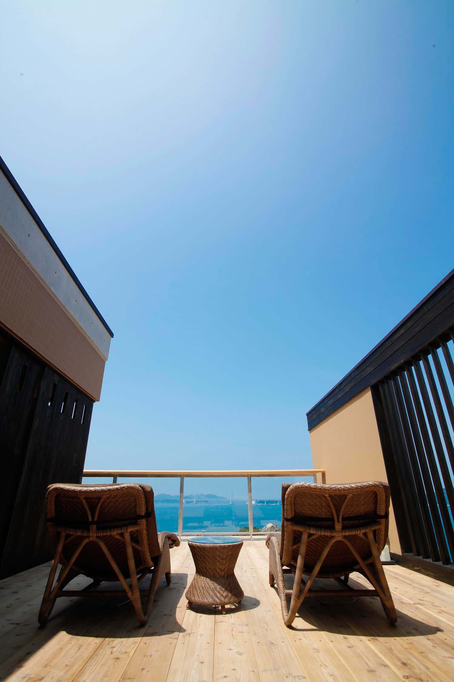 Tatami guest room with low seating and ocean view through large windows at Hotel New Awaji, Awaji Island