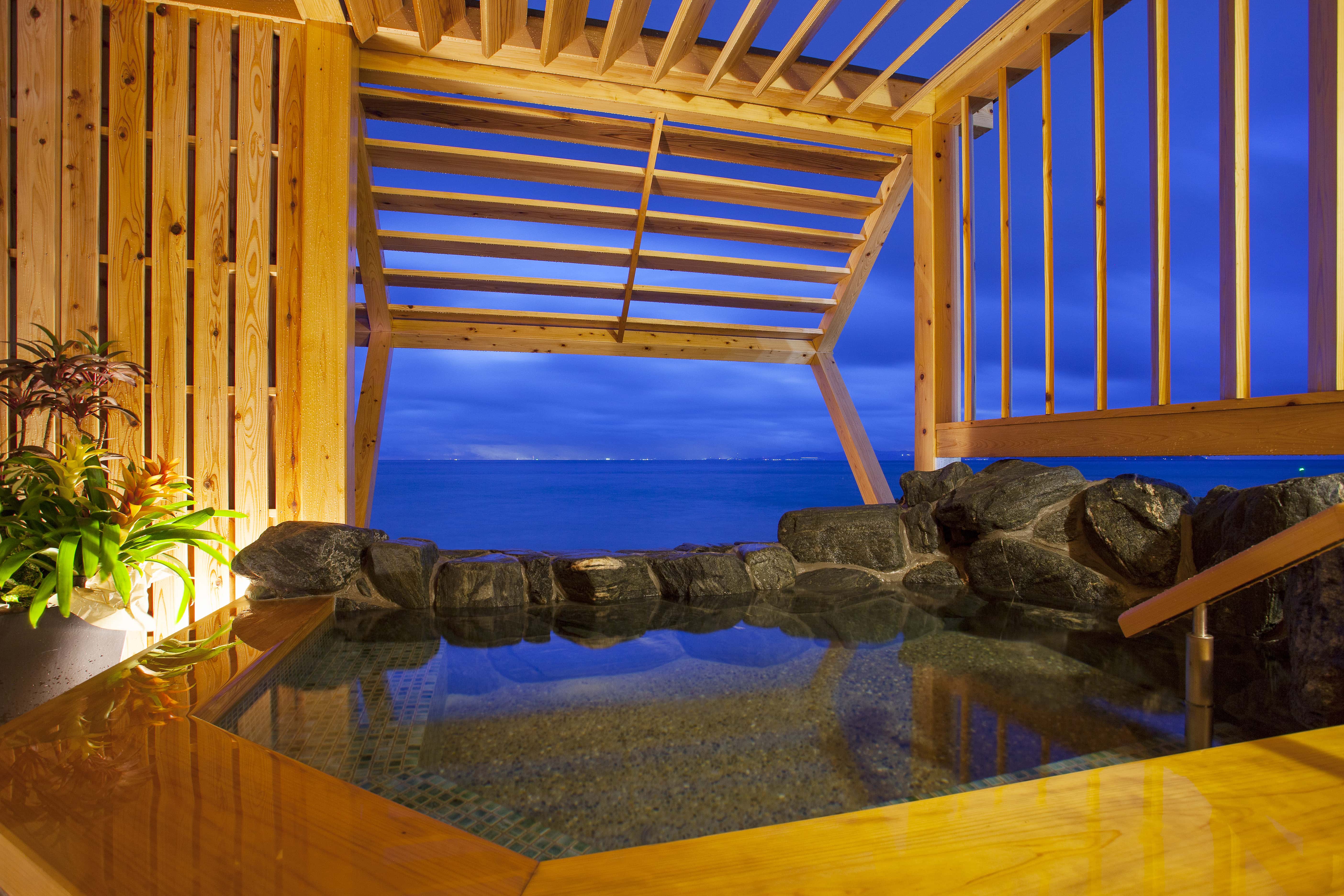 Open-air onsen bath with natural stone and ocean view, traditional Japanese hot spring on Awaji Island