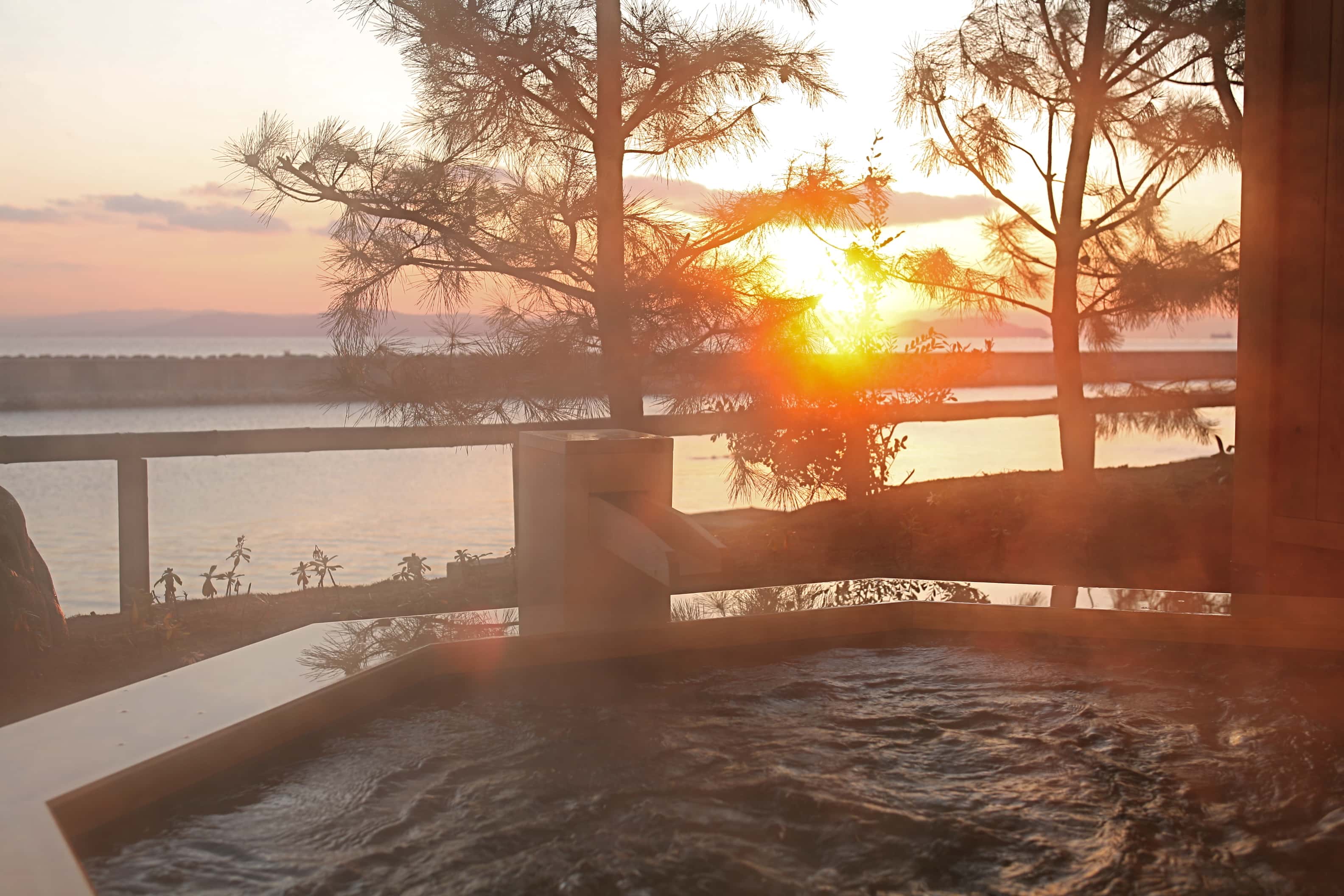 Outdoor onsen bath at sunset surrounded by nature, tranquil hot spring experience on Awaji Island