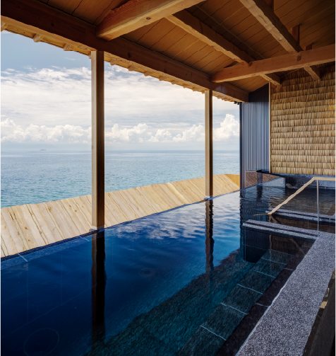 Open-air onsen under wooden pavilion surrounded by forest, emphasizing a tranquil nature-immersed bathing experience