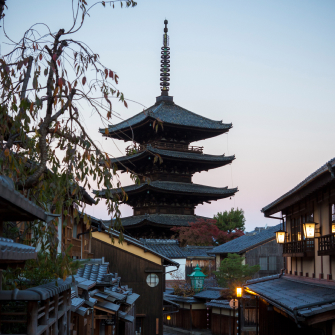 Traditional Kyoto pagoda above historic streets at dusk, reflecting timeless culture and heritage