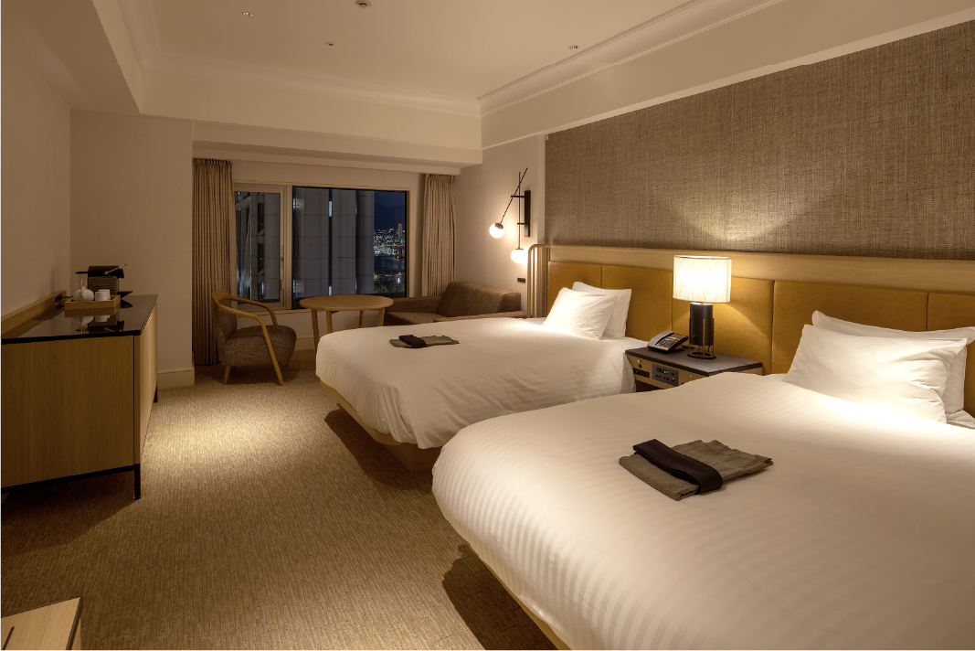Deluxe Twin Room at Hotel New Awaji Group's Lake Biwa property with warm wood tones, patterned bedding, and an open terrace framing serene views of the surrounding landscape