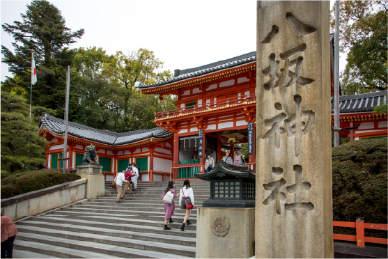 Visitors walking beneath layered vermillion torii gates at a Kyoto shrine, immersed in one of Japan's most iconic sacred landscapes