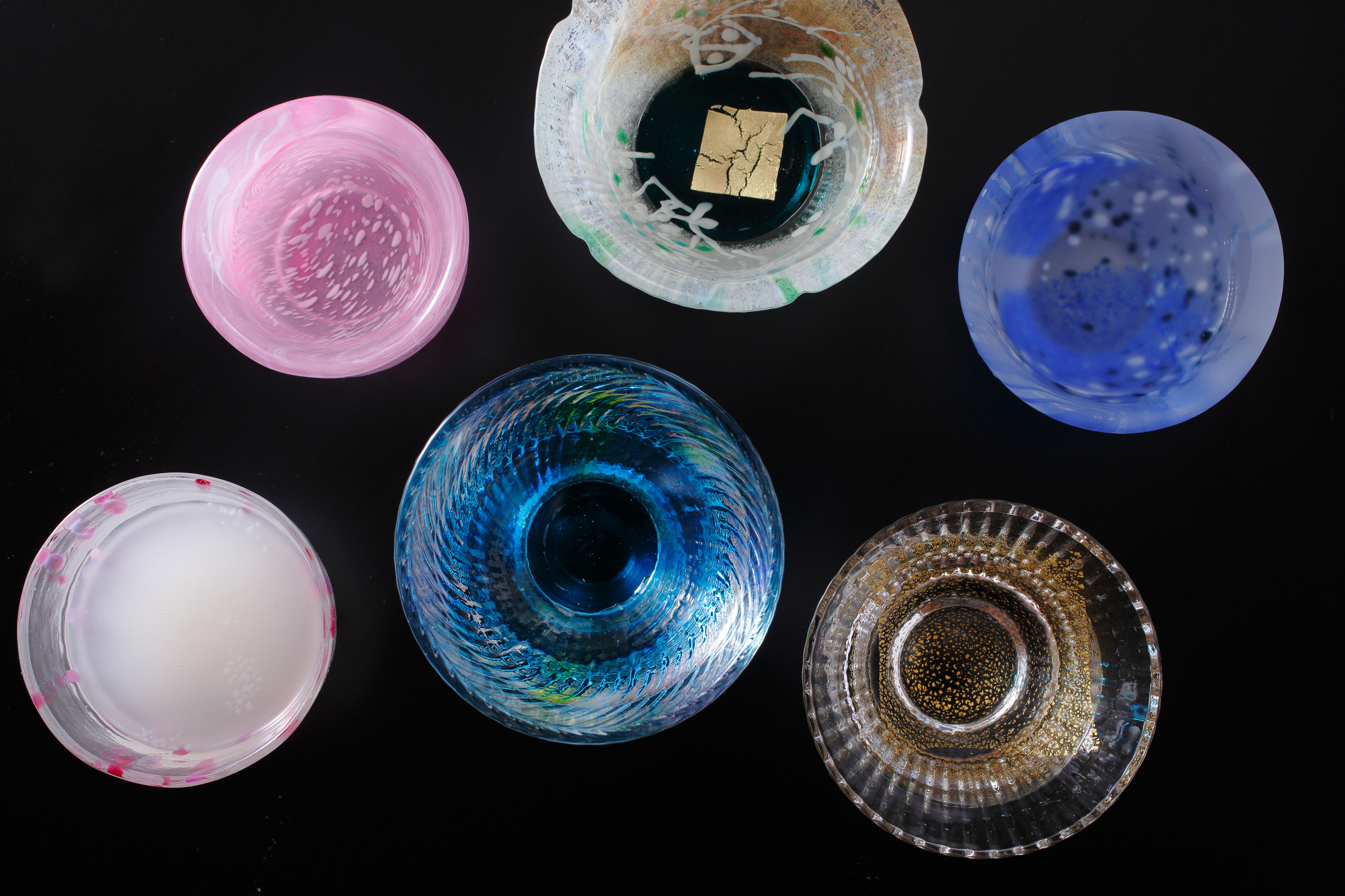 Delicate handcrafted glass bowls in soft pink, blue, and clear tones, showcasing the refined artisan traditions of the Lake Biwa region