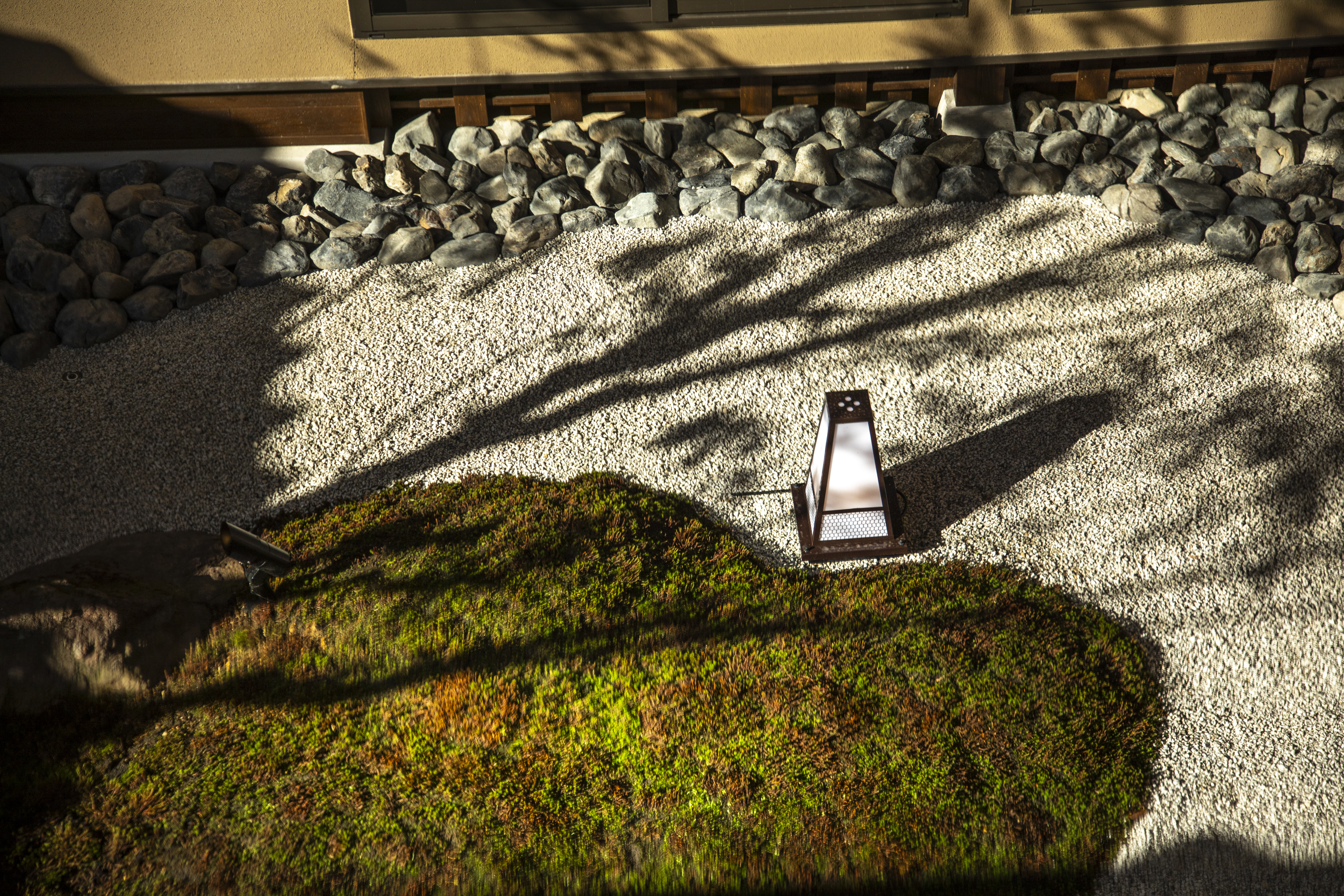 Raked zen garden with sculpted moss mounds and stone, offering a moment of quiet contemplation amid Lake Biwa's cultural landscape