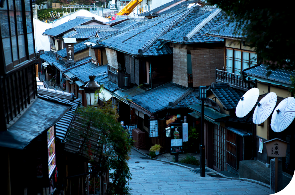 Narrow Kyoto backstreet lined with traditional machiya townhouses, capturing the city's layered everyday character beyond its famous landmarks