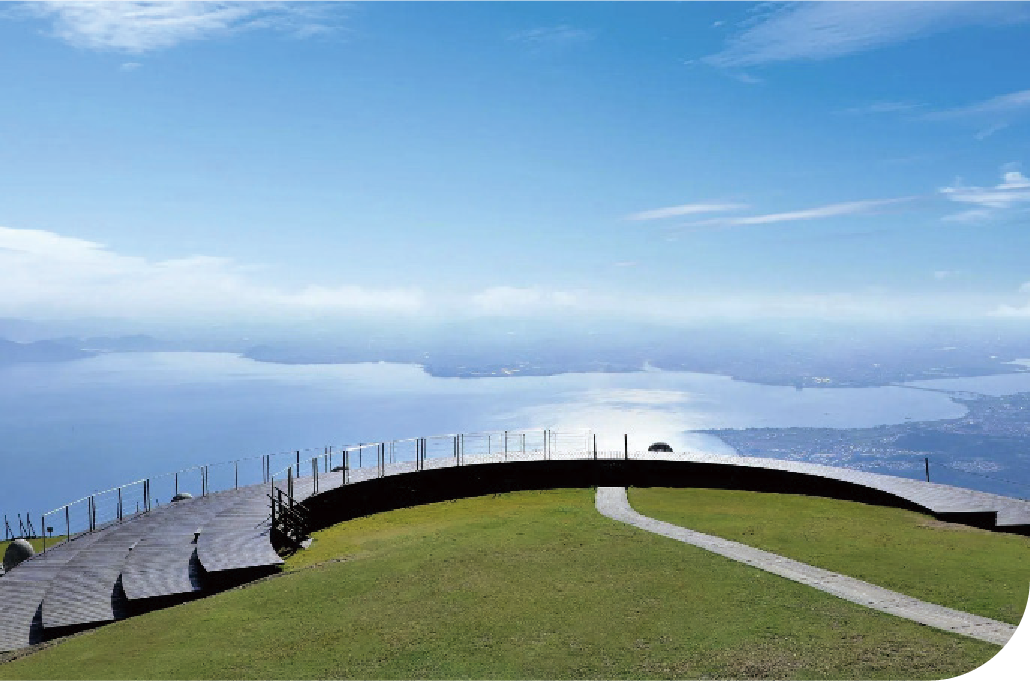 Curved lakeside promenade overlooking the open expanse of Lake Biwa with distant mountain silhouettes, inviting calm reflection and open-air exploration