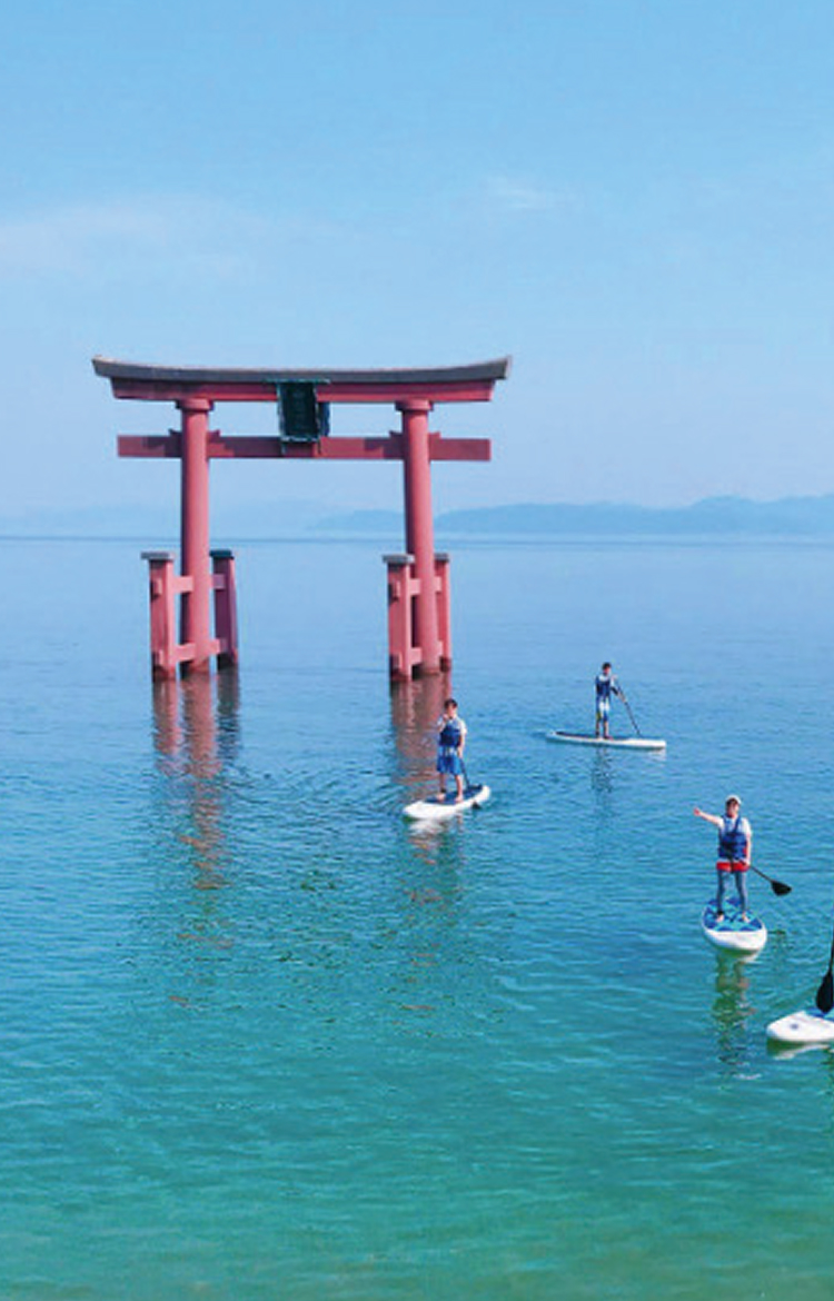 Scenic attractions near Hotel New Awaji Lake Biwa: a hilltop observation deck overlooking Lake Biwa, and the red torii gate of Shirahige Shrine with paddleboarders on the water