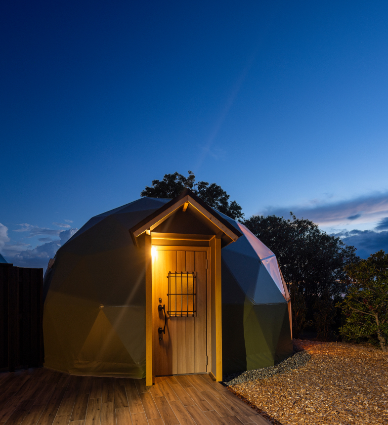 Illuminated geodesic glamping dome villa at twilight at Hotel New Awaji Biwa Lake in Hikone, Shiga, Japan, surrounded by nature near Lake Biwa