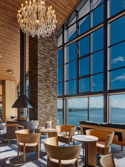 Grand double-height lounge at Hotel New Awaji Biwa Lake in Hikone, Shiga, Japan, with a crystal chandelier and floor-to-ceiling windows overlooking Lake Biwa and distant mountains