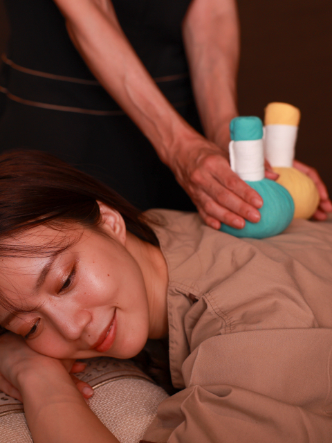 Guest receiving a relaxing herbal compress massage during a spa treatment at Hotel New Awaji Lake Biwa