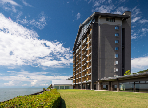 Hotel New Awaji Group lakeside resort exterior with open grounds and expansive lake views, offering a refined retreat beside Japan's largest freshwater lake