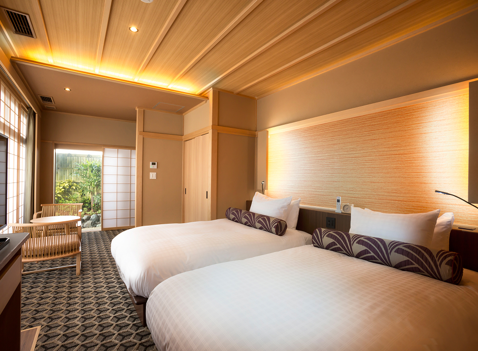 Saka Hotel Kyoto guest room with twin beds and warm wood interiors, offering a refined and comfortable stay in Kyoto's historic district