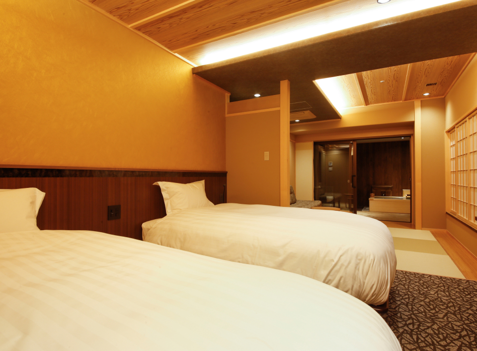 The Shiroyama Terrace Tsuyama Villa guest room with modern beds and warm lighting, offering a comfortable and contemporary stay in Okayama