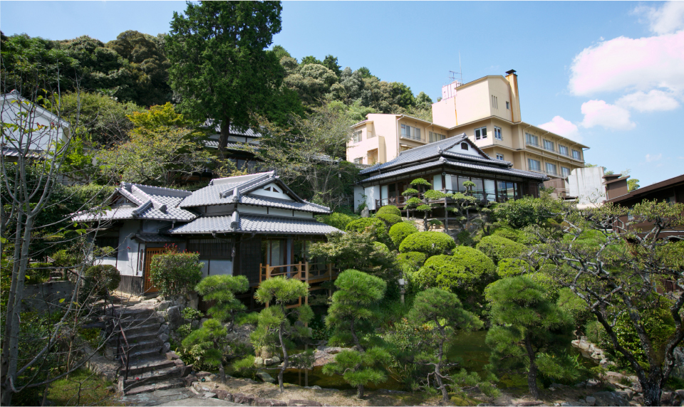 Traditional tiled rooflines and sculpted pine garden capturing the distinct character of Hotel New Awaji Group's two Shikoku and Okayama properties