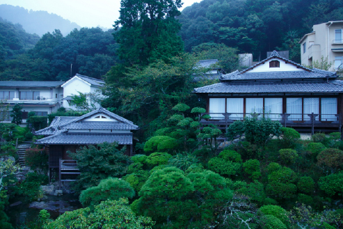 Hotel New Awaji Group property nestled into dense forest hillside in Shikoku, offering a stay defined by stillness and natural surroundings